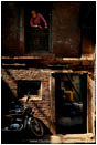 Rights Managed Stock Photo: Old Woman Looking Out On The Alley