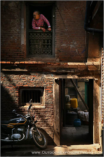 Old Woman Looking Out On The Alley Stock Image, Kathmandu, Nepal Old Woman Looking Out On The Alley Stock Image, Kathmandu, Nepal